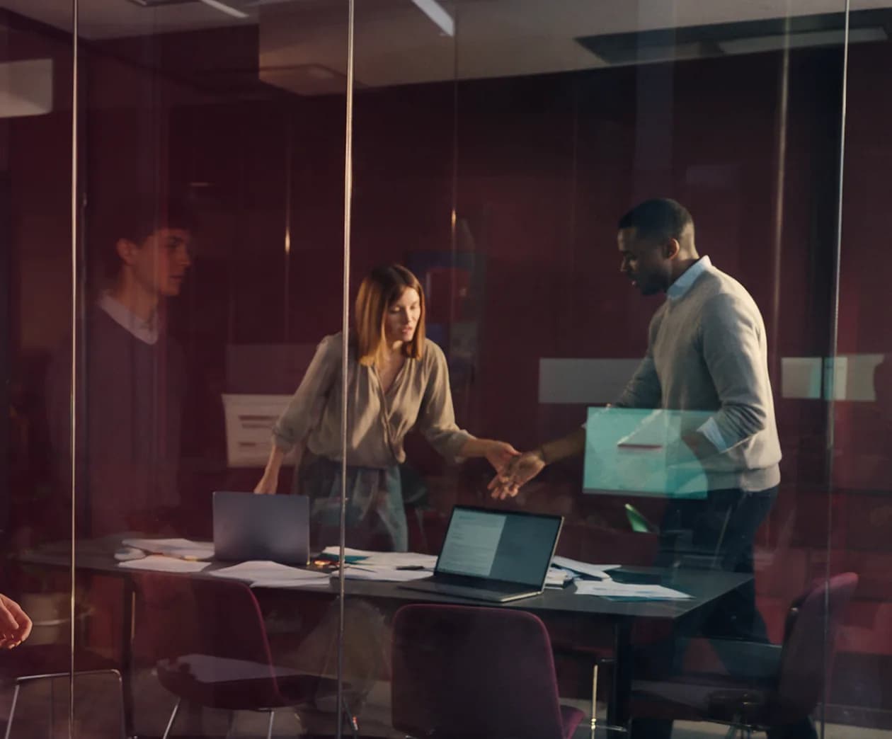 Colleagues collaborating in a glass-walled meeting room
